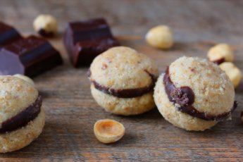 Baci di dama, biscotti classici alle nocciole ripieni di cioccolato fondente.