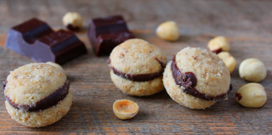 Baci di dama, biscotti classici alle nocciole ripieni di cioccolato fondente.